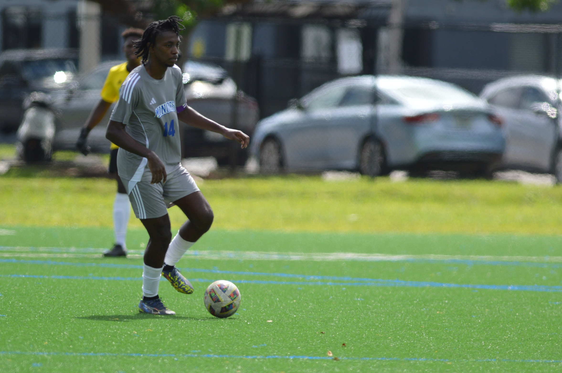 The University of The Bahamas captain and defender Joshua Johnson (#14 Gray) dribbles the ball up during his match against United International College at the Dowdy Field in Hollywood, Florida, October 2. UB won 2-1. UB ATHLETICS.